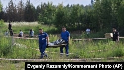 Russian authorities carry the body of former Transport Minister Roman Starovoit, who was found dead from a gunshot wound hours after being sacked by President Putin.