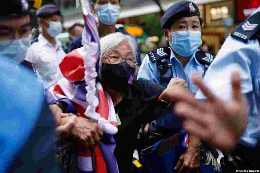 Un protestatar pro-democrație cu un steag britanic este reținut de poliție în timpul aniversării Partidului Comunist în Hong Kong. Centenarul din 1 iunie a coincis cu cea de-a 24-a aniversare a revenirii Hong Kong-ului sub autoritatea Chinei. Oficialii de la Beijing au reprimat dur activiștii opoziției din Hong Kong în ultimul an.