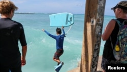 Turiștii revin pe plajă după ridicarea alertei de tsunami în Honolulu.