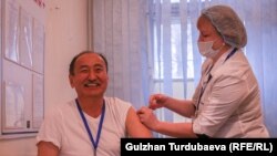 Министр здравоохранения и социального развития Кыргызстана Алымкадыр Бейшеналиев получает прививку от коронавируса.