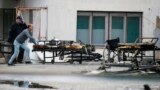 NORTH MACEDONIA -- A worker pushes charred beds at the site of destroyed field hospital following a fire in North Macedonia's northwestern city of Tetovo, September 9, 2021