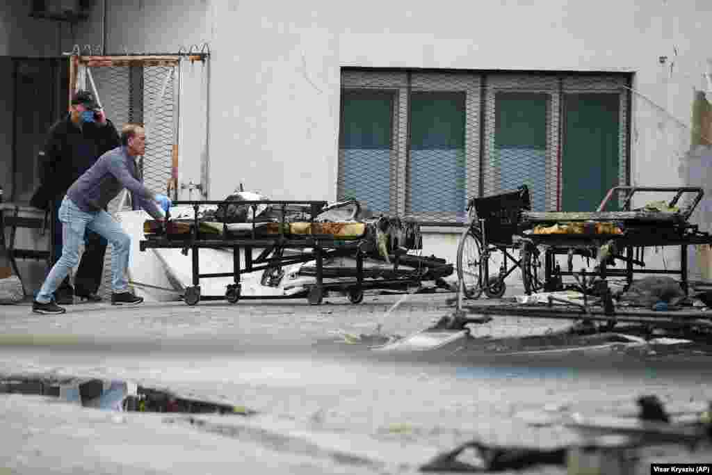 Zdravstveni radnik gura bolnička kolica ispred spaljene COVID bolnice u Tetovu, jutro poslije požara, 9. septembar