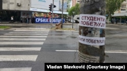 Pristalice SNS-a i lokalni funkcioneri sa transparentom "Srbija pobeđuje" naspram studenata koji su delili nalpenice "Studenti pobeđuju" u Kraljevu, 29. aprila 2026.