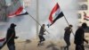 U.S. forces (unseen) fire teargas canisters at supporters and members of the Hashed al-Shaabi paramilitary force during a demonstration outside the US embassy in the Iraqi capital Baghdad on January 1, 2020.