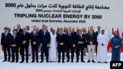 Emmanuel Macron francia elnök (középen) és a Tripling Nuclear Energy by 2050 résztvevői összeálltak egy csoportképre Dubajban, az ENSZ éghajlat-csúcstalálkozóján 2023. december 2-án