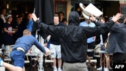 یکی از هواداران افراطی روسیه صندلی‌های کافه‌ای را به سوی هواداران انگلستان پرتاب می‌کند