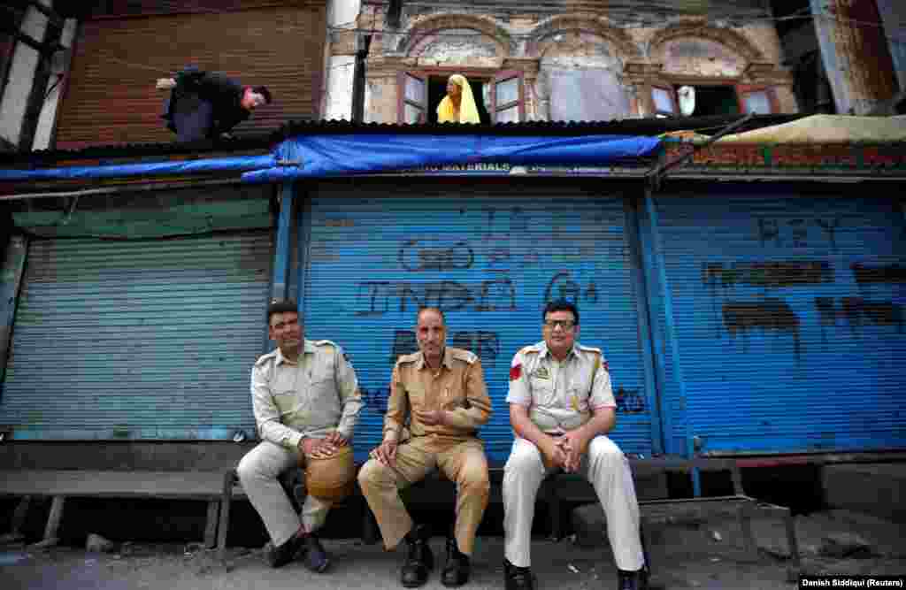 Indian police in front of shuttered shops in Srinigar on August 6. Pakistan has downgraded diplomatic links with India and suspended trade in protest of New Delhi&#39;s move.&nbsp;