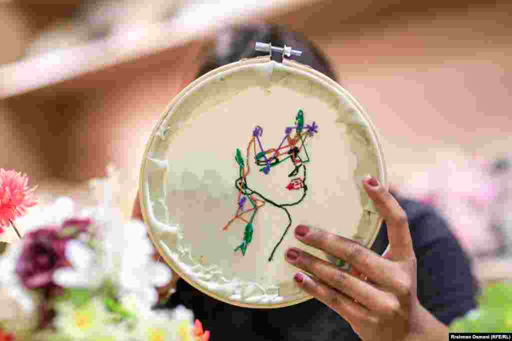 S iglom u ruci i šarenim koncima, uče kako ukrasiti tkaninu fiksiranu u okvire za vez.