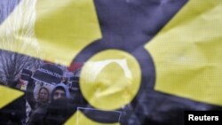 Antinuclear protesters are seen through a banner with a radioactivity sign at a demonstration in Berlin earlier this month. 