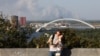 A couple takes a selfie in a park in Kyiv on September 16 while a plume of smoke from a forest fire in the Kyiv region is seen billowing in the sky.