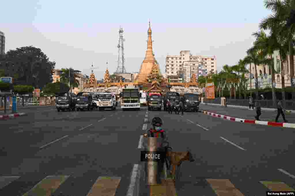 Поліція охороняє перекриту дорогу біля мерії Янгона (праворуч) і пагоди Сулі (в центрі). Янгон, 16 лютого 2021 року
