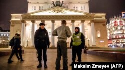 A police officer and a security staff member speak with a passerby outside the Bolshoi Theatre in Moscow after a bomb threat in early November.