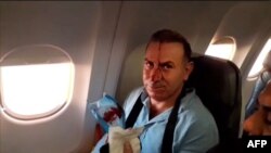 An image grab from a video released by state-run Iran Press news agency on July 24, 2020, reportedly shows a passenger with blood dripping on his face, on an Iranian passenger plane after it was intercepted by a US F-15 while flying over Syria.