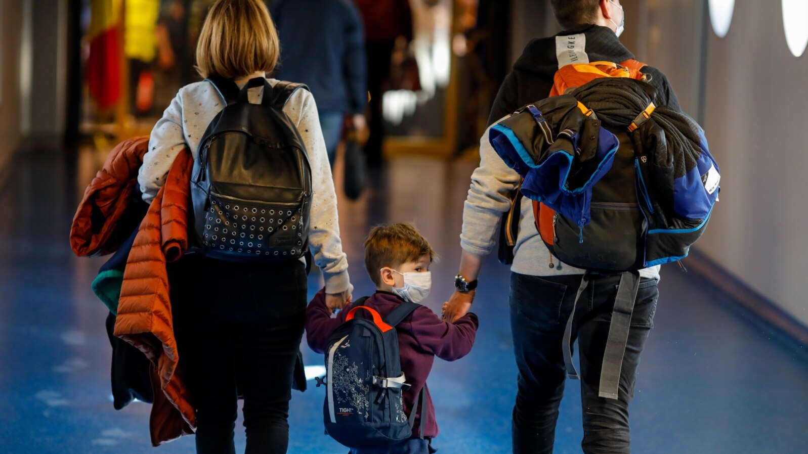O familie purtând măști chirurgicale, pe aeroportul Otopeni din Bucuresti