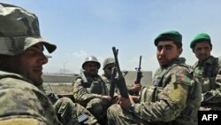 Afghan soldiers arrive at the gate of an international military compound in Kabul.