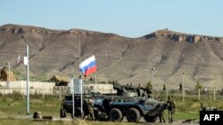 Nagorno-Karabakh - Russian peacekeepers stand next to an armored vehicle at the checkpoint outside Stepanakert, October 7, 2023.