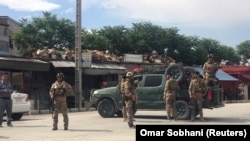 Afghan security forces keep watch outside a mosque where a blast occurred in Kabul on May 24.