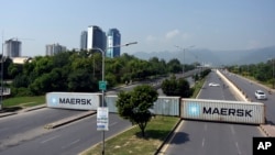 Containers block roads to Islamabad as Pakistani security forces attempt to impede protesters on October 5.