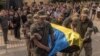 Soldații ucraineni purtând un sicriu, acoperit cu steagul național, al militarului ucrainean Iuri Iurcenko, ucis în luptele din regiunea Lugansk, în timpul slujbei funerare care a avut loc la Kiev, pe 3 august.