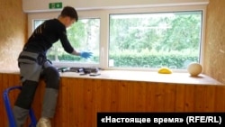 Робітник наклеює на вікна у школі захисну плівку. Естонія, місто Тарту. Липень 2026 року 