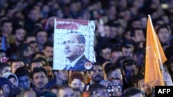 Supporters of the Justice and Development Party (AKP) hold a banner of Turkish President Recep Tayyip Erdogan during a speech by Prime Minister Ahmet Davutoglu at AKP headquarters in Ankara, on November 2.