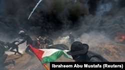 PALESTINE -- Palestinian demonstrators run for cover from Israeli fire and tear gas during a protest against U.S. embassy move to Jerusalem and ahead of the 70th anniversary of Nakba, at the Israel-Gaza border in the southern Gaza Strip, May 14, 2018