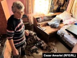 Ștefana Bodea încearcă să mai salveze ce se poate din casa inundată în urmă cu două zile. În câteva minute, nivelul apei urcase până la piept iar femeia și familia s-au refugiat în pod unde au stat zece ore, până când au fost salvați.