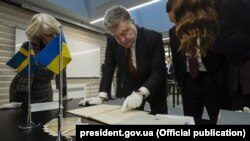 Президент України Петро Порошенко переглядає першу Конституцію України, написану гетьманом Пилипом Орликом у 1710 році. Стокгольм, Національний архів Швеції,14 листопада 2016 року 