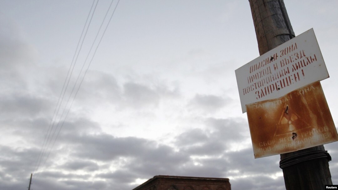 A sign forbids gathering mushrooms, picking berries, and fishing in front of an abandoned school in the village of Muslyumovo, located in Russia's Urals, one of the country's most lethal nuclear dumping grounds.