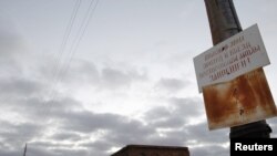 A sign forbids gathering mushrooms, picking berries, and fishing in front of an abandoned school in the village of Muslyumovo, located in Russia's Urals, one of the country's most lethal nuclear dumping grounds.