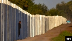 A migrant peeks through a gap in the border fence before entering Hungarian territory along the Hungarian-Serbian border, near Roszke, on September 7.