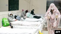 На этой фотографии, сделанной 5 февраля 2020 года, изображены пациенты, в выставочном центре, преобразованном в больницу, которая принимает пациентов с легкими симптомами нового коронавируса в Ухане в центральной провинции Хубэй в Китае.