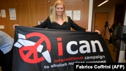 International Campaign to Abolish Nuclear Weapons executive director Beatrice Fihn holds a banner with its logo after ICAN won the Nobel Peace Prize on October 6.