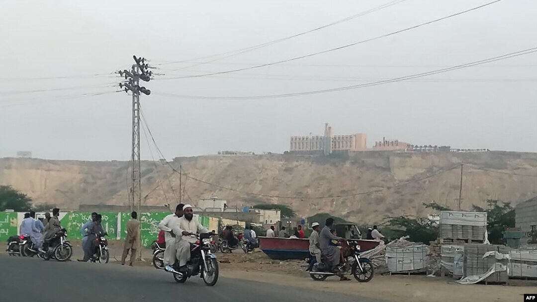 Pakistan -- Pakistani residents watch from a road the five-star Pearl Continental hotel, located on a hill (top back) in the southwestern Pakistani city of Gwadar, on May 11, 2019. 