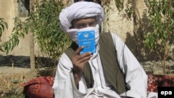 Mullah Wakeel, a Taliban leader, show a copy of the Afghan Taliban's code of conduct. Scholars say the Taliban has no authority to enforce Islamic law.