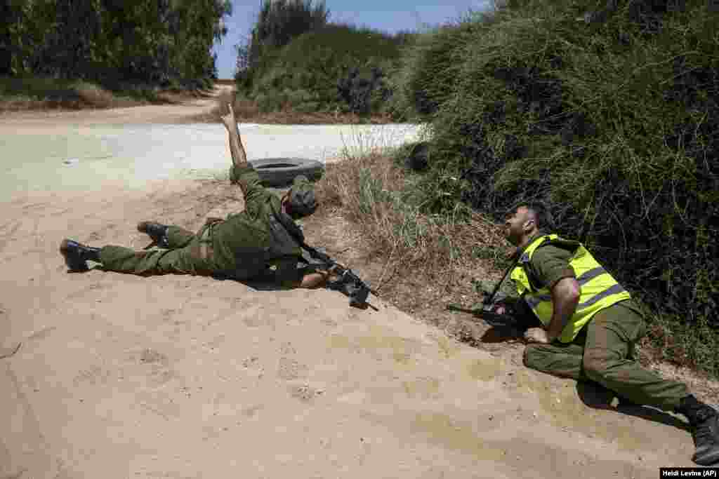 Ізраїль. Ізраїльські солдати лежать на землі в момент, коли сирена попереджає про наближення ракет, випущених зі Смуги Гази. Південь Ізраїлю, 17 травня 2021 року (Фото AP / Heidi Levine)