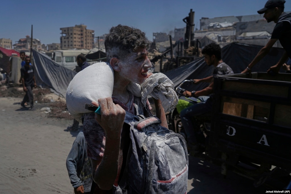 Një palestinez me një thes me miell mbi supe, më 22 korrik.