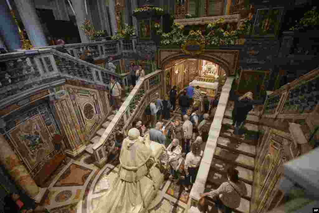 Roma, 22 aprilie 2025 - Credincioși și călugărițe în fața statuii Papei Pius IX, din interioriul Bazilicii Santa Maria Maggiore, locul în care va fi înmormântat Papa Francisc.
