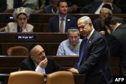 Netanyahu (dreapta) a fost externat luni dimineață, după montarea de urgență a unui stimulator cardiac, și s-a aflat în Parlament. Aici, împreună cu Aryeh Deri, un aliat apropiat, lider al partidului ultra-ortodox Shas. Curtea Supremă a respins în ianuarie numirea lui în funcția de ministru de Finanțe, într-o mișcare pe care votul de luni o face imposibilă în viitor.