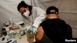 په جرمني کې یو کس د کرونا ضد واکسین تطبیقوي