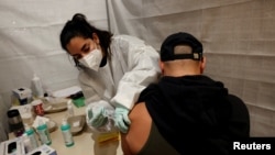 Zdravstveni radnik daje vakcinu protiv korona virusa (COVID-19) osobi u centru za vakcinaciju u tržnom centru Alexa u Berlinu, Njemačka, 9. novembra 2021. 