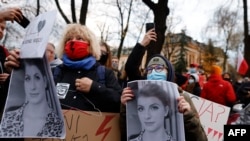 Un grup de femei în timpul unui protest organizat pe 6 noiembrie 2021 la Varșovia, Polonia. Ele au mai multe fotografii cu Iza, care a murit din cauza complicațiilor din timpul sarcinii.
