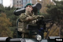 A Turkish-made Cobra armored vehicle rolls by, equipped with a PK machine gun and a Belarusian-made Shershen anti-tank missile. The parade showcased much of the military hardware oil-rich Azerbaijan has purchased on the global arms market in recent years.