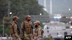 Pakistani soldiers stand guard on a street leading to the Red Zone area after tightened security measures on April 24.
