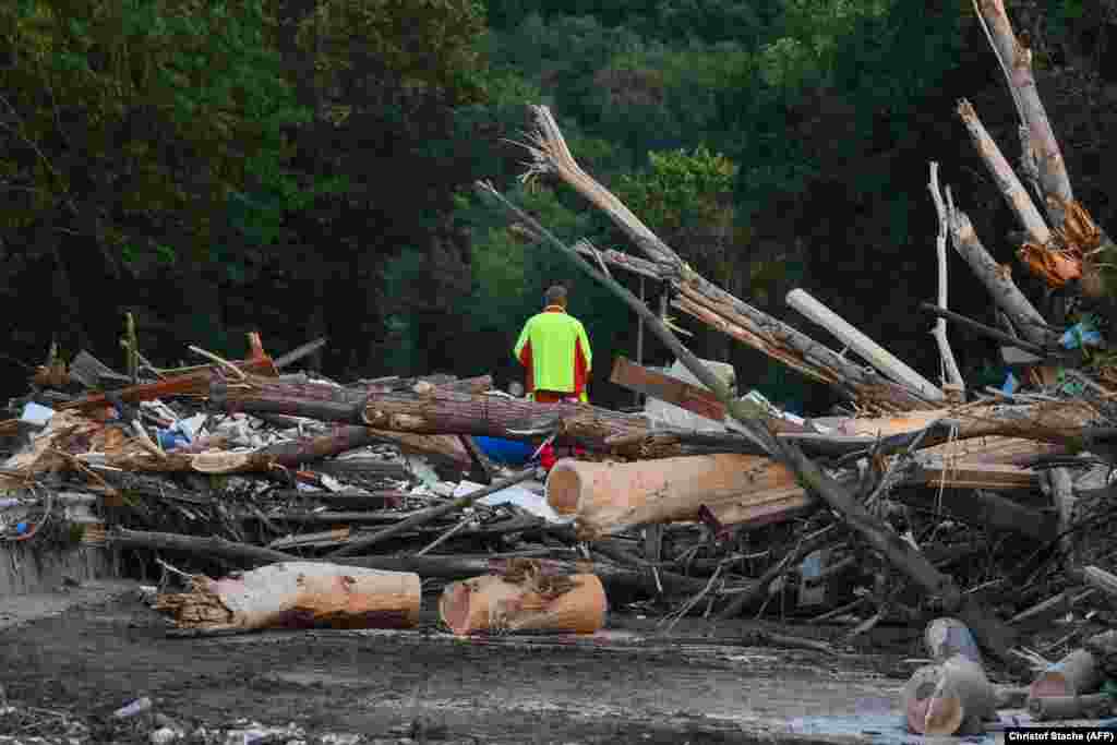 Мужчина стоит на поврежденном мосту из разорванных деревьев и обломков в Бад-Нойенар-Арвайлере, западная Германия, 17 июля 2021 года
