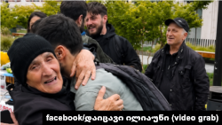 13 წლის ნიკოლოზის ბებია, ცისანა ტეფნაძე ეხუტება მარათონის ერთ-ერთ ინიციატორს. მთავრობის ადმინისტრაციის სკვერი. 22 მაისი, 2026 წელი