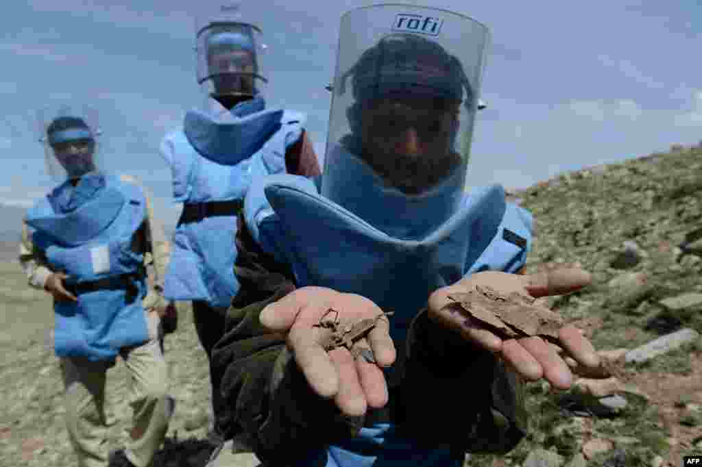 A sapper displays pieces of land mines in the village of Sangaw on the outskirts of Kabul. (AFP/Shah Marai)