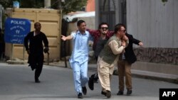 Supporters of Afghan Vice President Abdul Rashid Dostum carry a wounded colleague during clashes at the reburial of Habibullah Kalakani, a controversial Afghan monarch who died in 1929.
