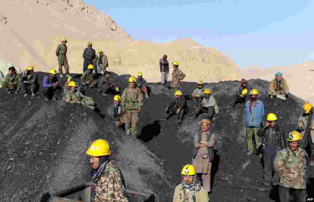 Miners wait on September 16 to remove the bodies of their colleagues who died in a mine collapse in the Ruyi Du Ab district of Samangan Province.