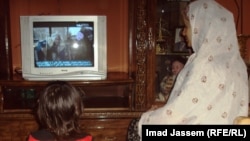 سيدة عراقية تتابع مسلسلا نلفزيونيا